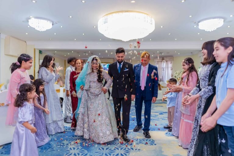 Bride and groom standing with family and guests in a bright reception hall