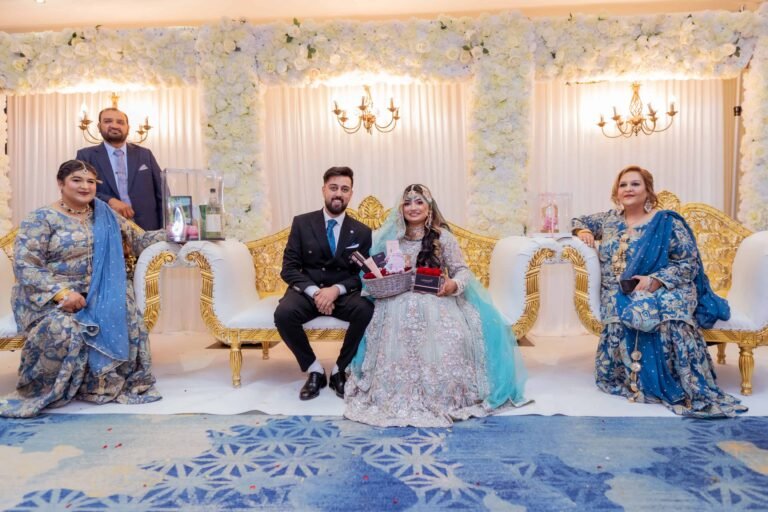 Couple seated on a wedding stage with family members on either side