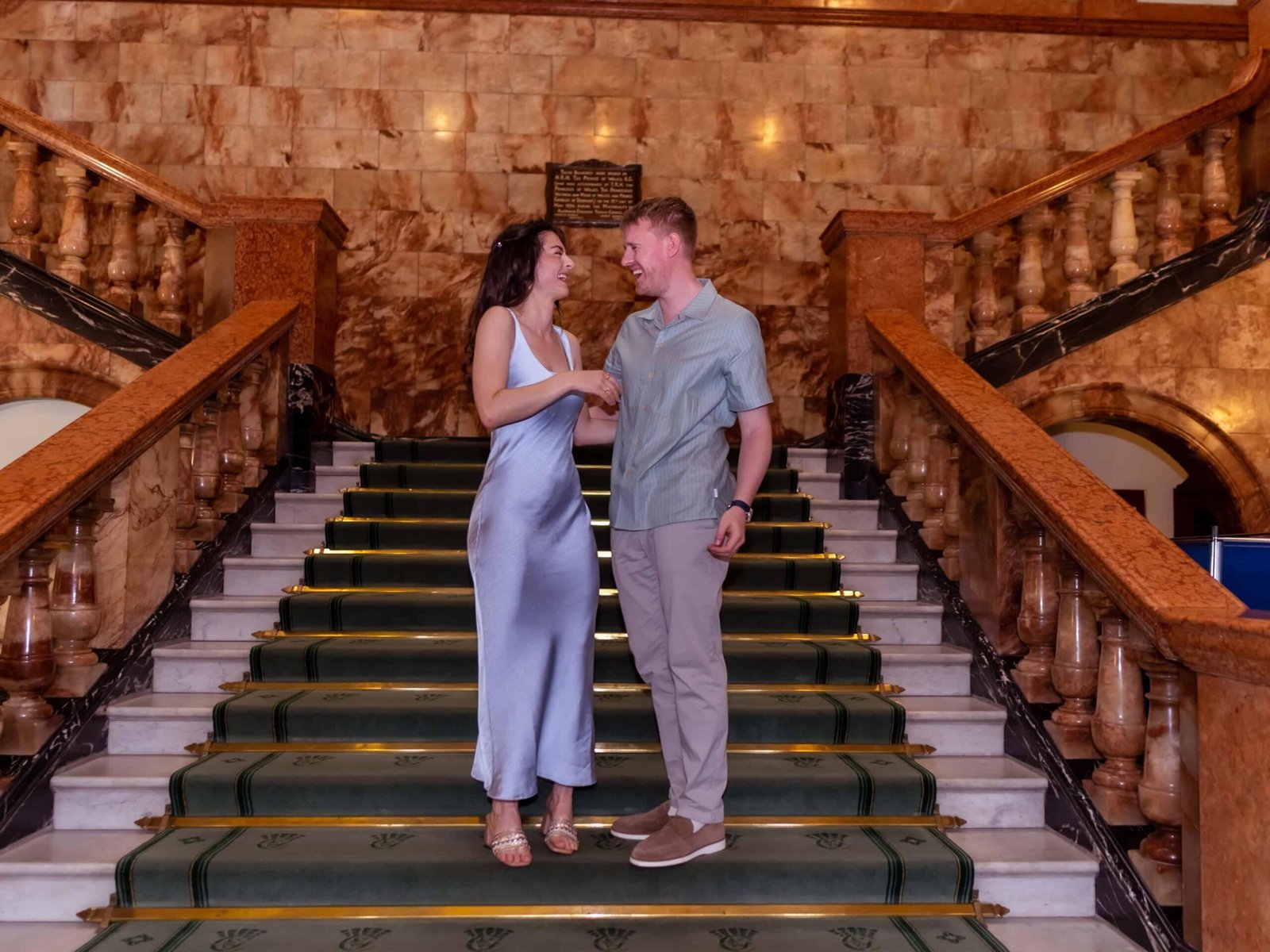 Bride in a blue satin gown and groom on a grand manor staircase – natural wedding photography in Wedding Photographer Colchester