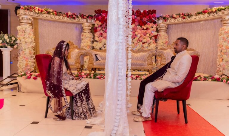 Couple on a gold stage sofa before a lavish pink floral backdrop, Colchester