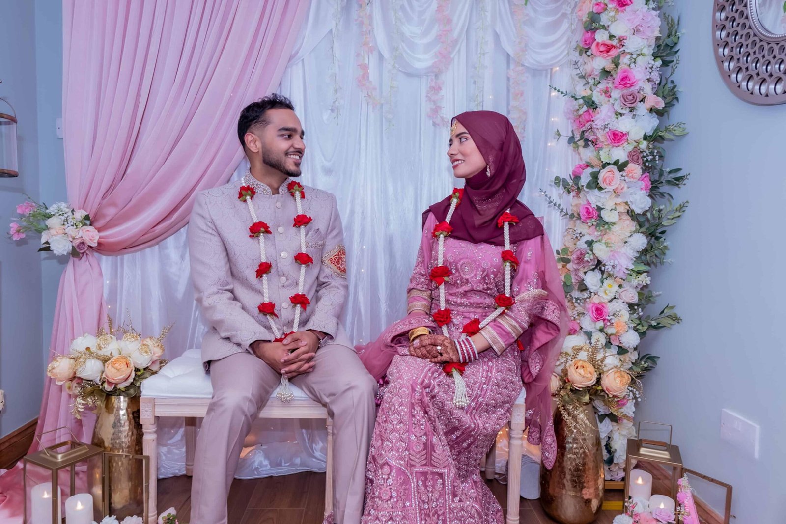 Black and white wedding ceremony with the groom seated at a floral backdrop