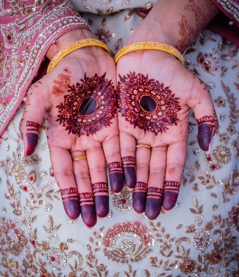 Close-up of a bride's henna-decorated hands and gold bangles