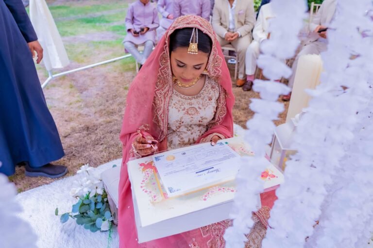 Bride in a pink outfit signing the marriage documents